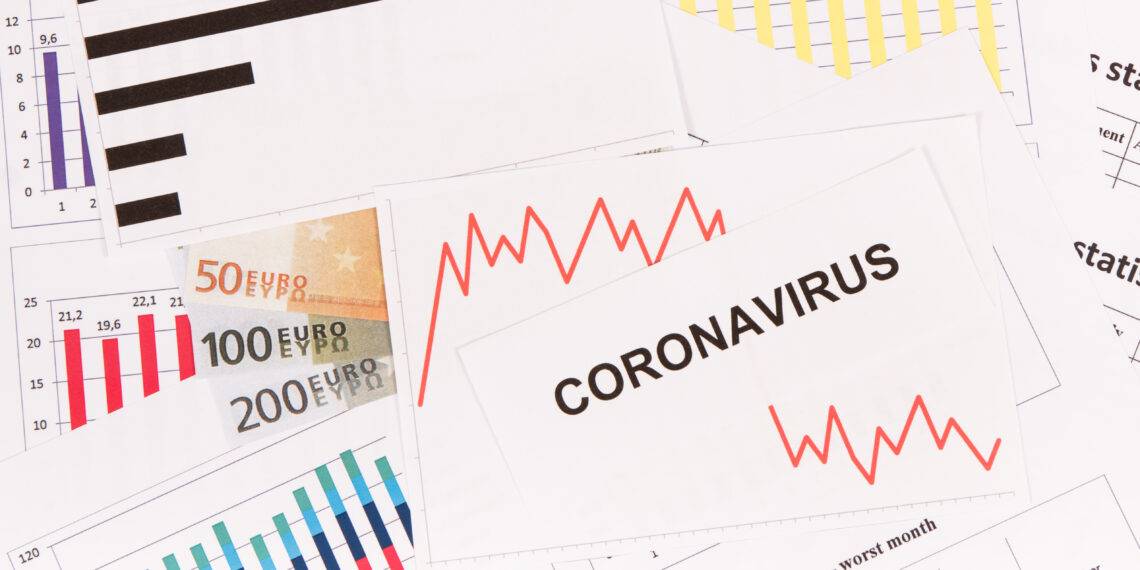 Inscription coronavirus, currencies euro and downward graphs representing financial crisis caused by Covid-19. Risk of global recession around world