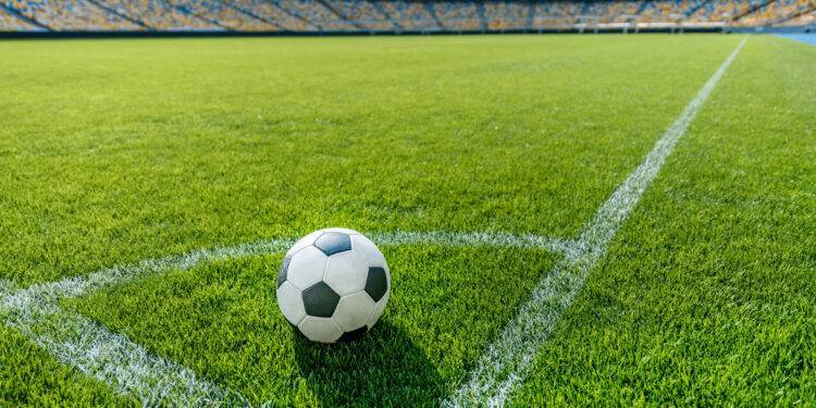soccer ball on grass in corner kick position on soccer field stadium