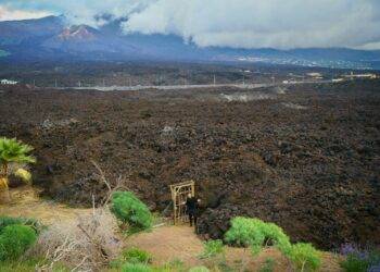a dirt field with a mountain in the background
