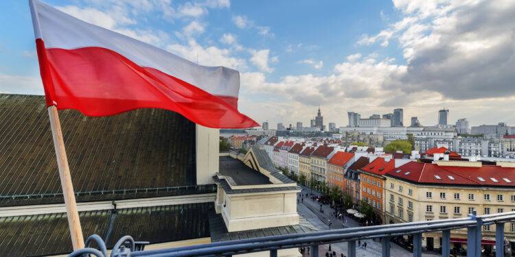 Poland Flag in Blue Sky and the centre of Warsaw in background