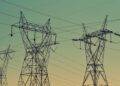black transmission towers under green sky