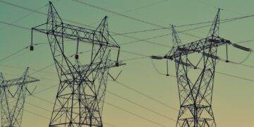 black transmission towers under green sky