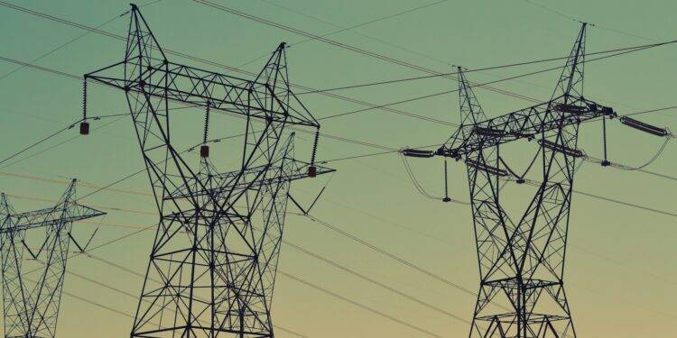 black transmission towers under green sky