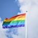 a rainbow flag flying high in the sky