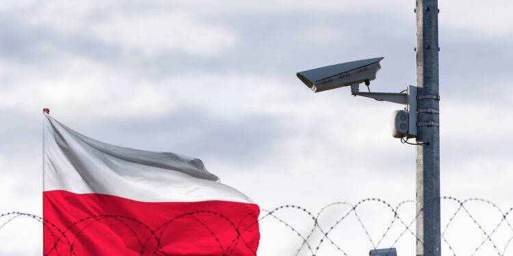 Poland flag behind of barbed wire and Surveillance camera.