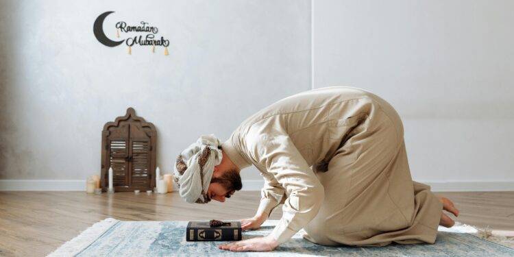 Man in traditional wear kneeling on a prayer rug