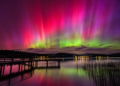 Vivid aurora over a lake at night illustrating the May 2024 geomagnetic storm