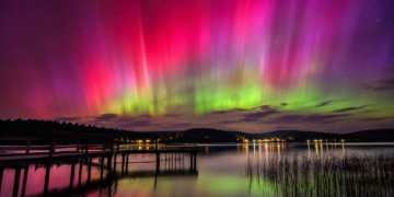 Vivid aurora over a lake at night illustrating the May 2024 geomagnetic storm