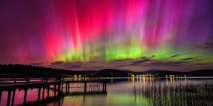 Vivid aurora over a lake at night illustrating the May 2024 geomagnetic storm