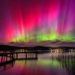 Vivid aurora over a lake at night illustrating the May 2024 geomagnetic storm