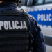 Close-up of a Polish police officer in tactical uniform beside a police vehicle
