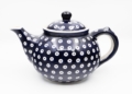 A cobalt-blue Bolesławiec ceramic teapot with white circular decorative motifs, photographed by Jacek Halicki, 2023.