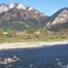 Traditional Dunajec raftsmen with passengers on a wooden raft travelling beneath the limestone peaks of Trzy Korony and Facimiech in the Pieniny Mountains, October 2006