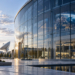 Digitally generated conceptual space technology campus with modern glass building, satellite communications equipment and Earth imagery; not an actual ESA facility.