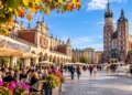 Editorial illustration of Kraków Main Market Square with St Mary's Basilica, Cloth Hall, outdoor cafés and people in an autumn city scene.
