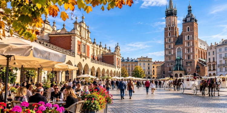 Editorial illustration of Kraków Main Market Square with St Mary's Basilica, Cloth Hall, outdoor cafés and people in an autumn city scene.