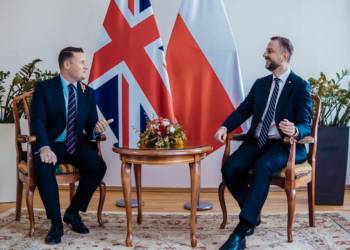 British Defence Secretary Wes Streeting and Polish Defence Minister Władysław Kosiniak-Kamysz in conversation beneath UK and Polish flags. Image source: gov.pl.