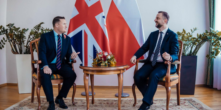 British Defence Secretary Wes Streeting and Polish Defence Minister Władysław Kosiniak-Kamysz in conversation beneath UK and Polish flags. Image source: gov.pl.