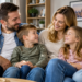 Digitally created illustrative image of two parents and two children seated together at home; not an actual photograph of benefit recipients.