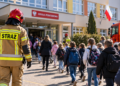 Digitally created illustrative image of a firefighter and pupils outside a Polish school, not an actual drill under the proposed regulations.