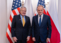 US Ambassador Thomas Rose and Prime Minister Donald Tusk pose together before US and Polish flags at a meeting in Warsaw in December 2025.