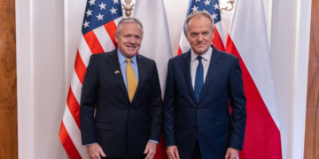 US Ambassador Thomas Rose and Prime Minister Donald Tusk pose together before US and Polish flags at a meeting in Warsaw in December 2025.