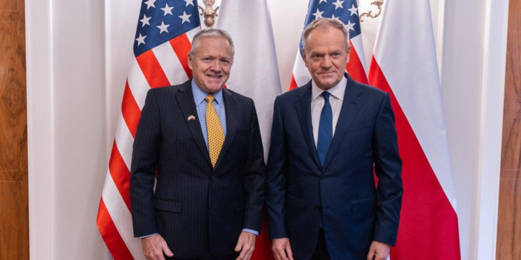 US Ambassador Thomas Rose and Prime Minister Donald Tusk pose together before US and Polish flags at a meeting in Warsaw in December 2025.