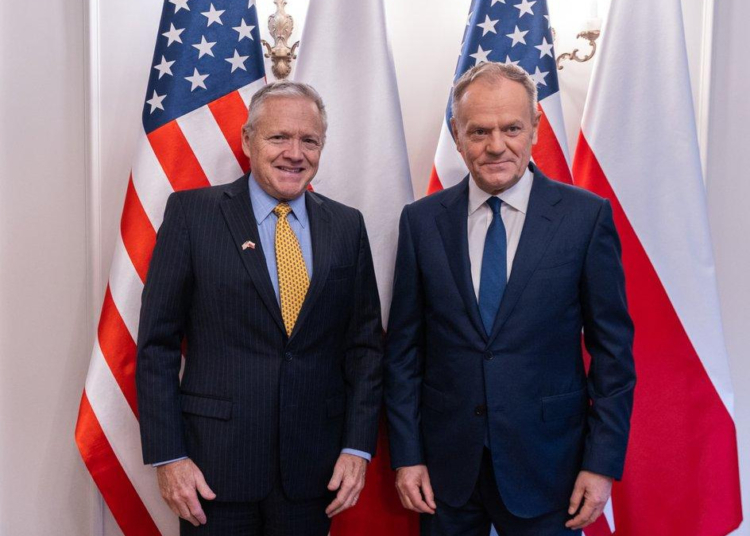 US Ambassador Thomas Rose and Prime Minister Donald Tusk pose together before US and Polish flags at a meeting in Warsaw in December 2025.