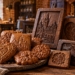 Illustration of elaborately decorated traditional Toruń gingerbread biscuits and carved wooden moulds in a rustic brick baking workshop