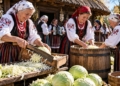 Editorial illustration of people chopping and pressing cabbage into a wooden barrel outside a rustic Polish farmhouse, with traditional-inspired dress and baskets of cabbages.