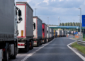 Digitally generated illustration showing a queue of freight lorries approaching a fictionalised Polish border checkpoint.
