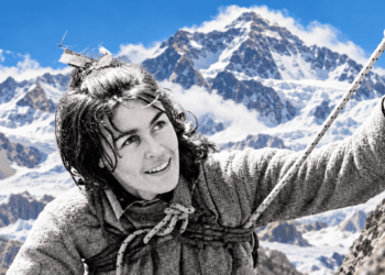 Editorial composite using an archival black-and-white portrait of Wanda Rutkiewicz with an added colour Himalayan background; not a photograph from her 1978 Everest summit