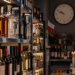 Alcohol bottles in a Polish shop at night with a wall clock after 10 p.m.
