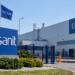 Digitally generated illustrative exterior of a Cersanit-branded factory with Polish and Ukrainian flags; not a photograph of the damaged factory.