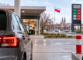 Car at a petrol station in Poland with fuel pumps and a Polish flag