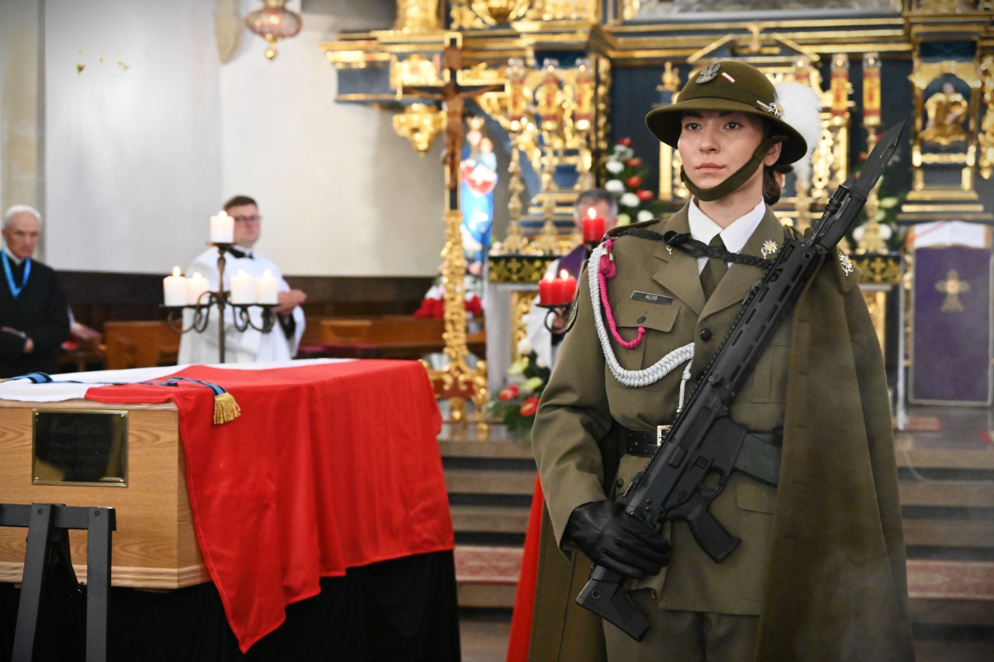Polish military honour guard beside General Józef Giza's flag-draped coffin in a church during the 2026 reburial ceremony
