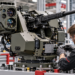 Illustrative scene of engineers assembling a counter-drone weapon station inside a defence manufacturing workshop