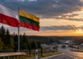 Polish and Lithuanian flags beside a border road, illustrating evacuation planning between Lithuania and Poland