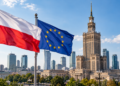 Digitally created editorial image of the Polish and European Union flags flying over Warsaw, with the Palace of Culture and Science in the background