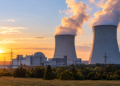 Illustration of a proposed nuclear power station with cooling towers at sunset; not an existing Polish plant.