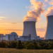 Illustration of a proposed nuclear power station with cooling towers at sunset; not an existing Polish plant.