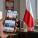 Digitally created illustration of a smartphone with a blurred social-media feed in a generic office, with a Polish flag in the background.
