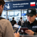 Digitally created illustrative scene of a traveller presenting a passport to a border officer at a Polish airport; not an actual checkpoint photograph.