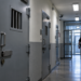 Illustrative police custody corridor with an officer walking away