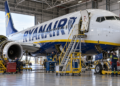 Ryanair Boeing 737 undergoing maintenance in a hangar with a Polish flag in the background