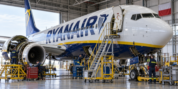 Ryanair Boeing 737 undergoing maintenance in a hangar with a Polish flag in the background