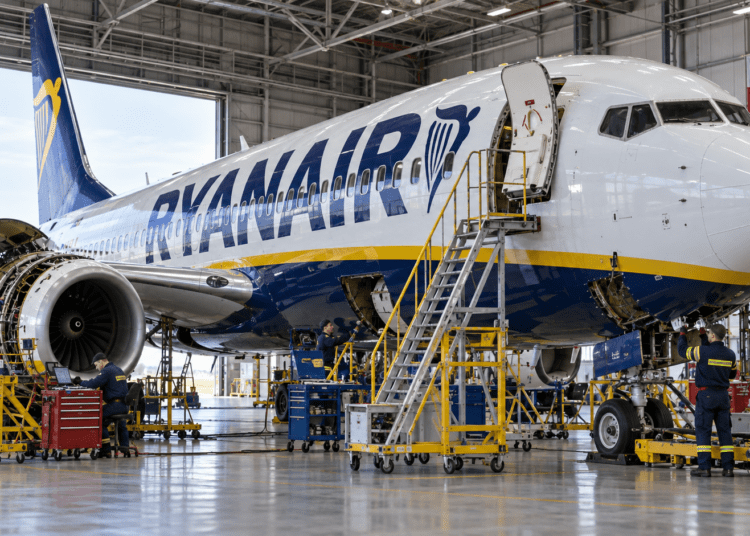 Ryanair Boeing 737 undergoing maintenance in a hangar with a Polish flag in the background