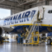 Ryanair Boeing 737 undergoing maintenance in a hangar with a Polish flag in the background
