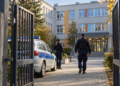 Polish police patrol entering a school courtyard through open gates