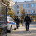 Polish police patrol entering a school courtyard through open gates